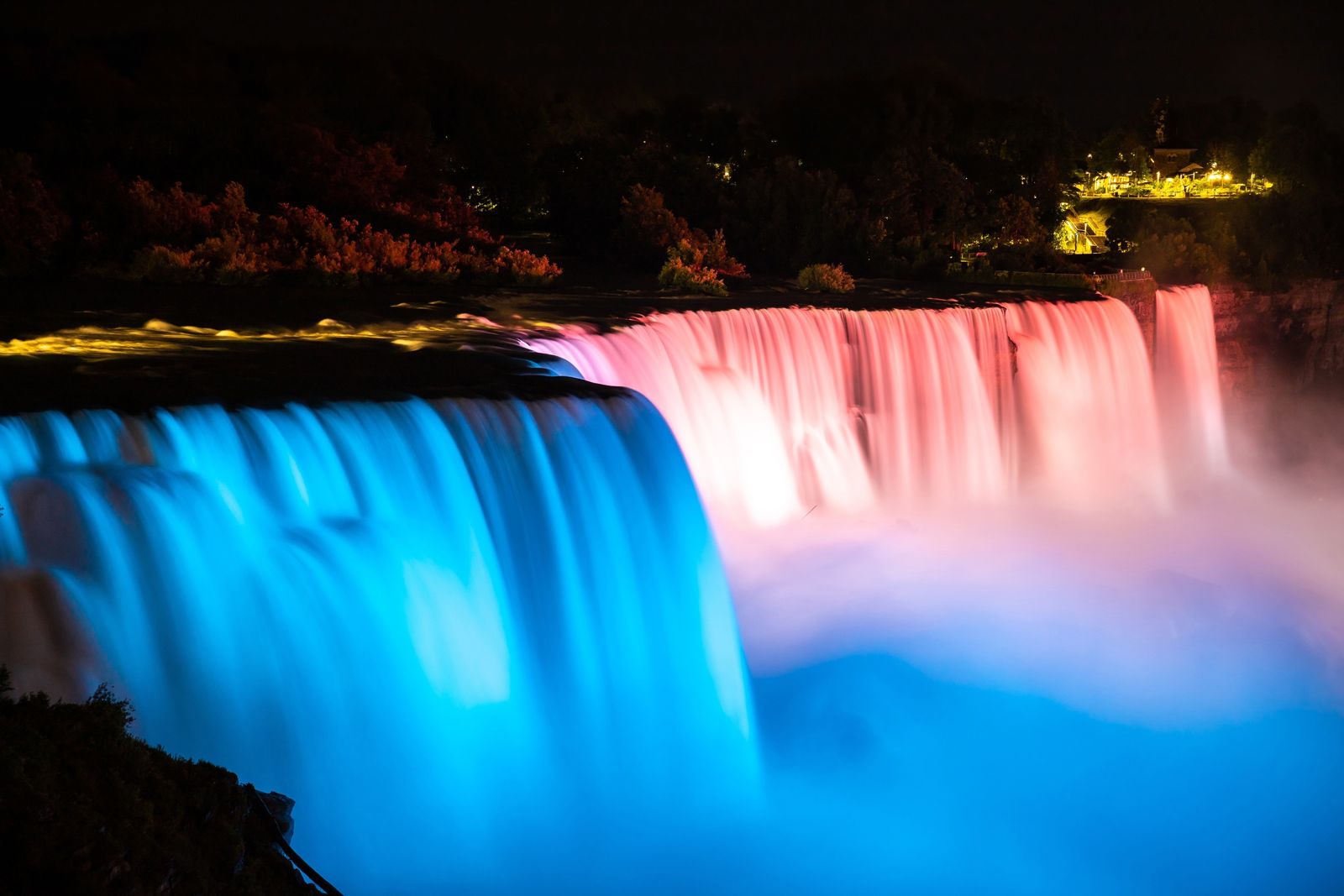 Niagara Falls lit in blue and pink at night